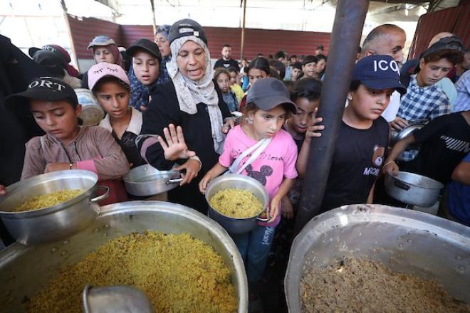نازحون يتلقون وجبات ساخنة في مخيم النصيرات وسط أزمة غذائية متفاقمة