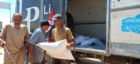 اللجنة المصرية توزع أكياس الطحين على الأسر في المخيم المصري 17